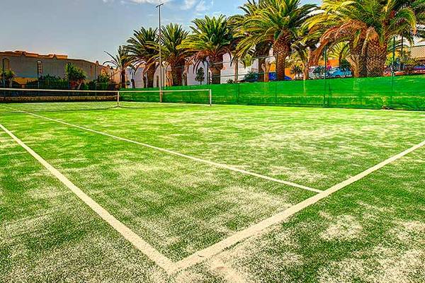 Tennisplatz im Freien mit weißem Sand und grünem Kunstrasen im SBH Monica Beach Resort