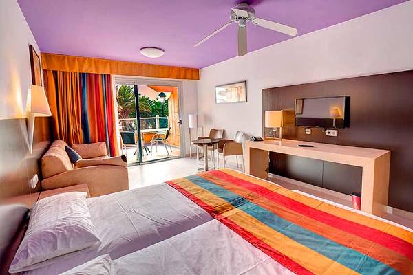 Hotelzimmer im SBH Monica Beach Resort mit Doppelbett, Balkon, Fernseher und Schreibtisch.