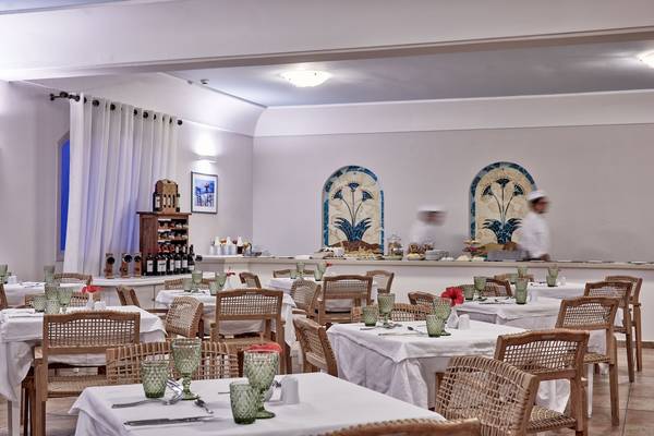 Innenraum des Restaurants im Santo Miramare Resort mit gedeckten Tischen und Dekor.
