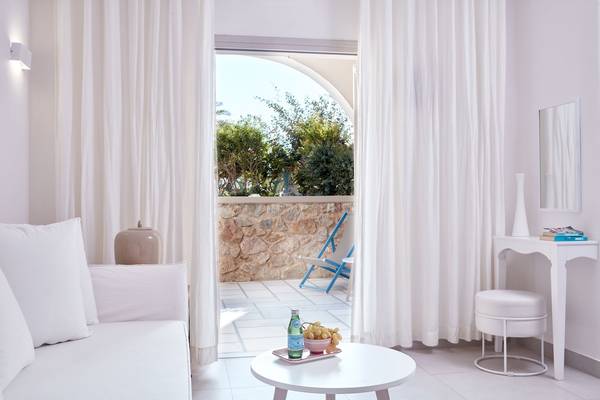 Innenbereich des Santo Miramare Resorts mit Sofa, Tisch und Terrassenblick.