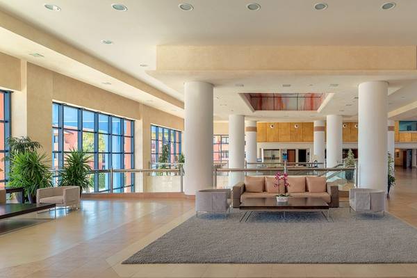 Empfangsbereich des H10 Tindaya Hotels mit Sofa, Couchtisch, Teppich und großen Fenstern.