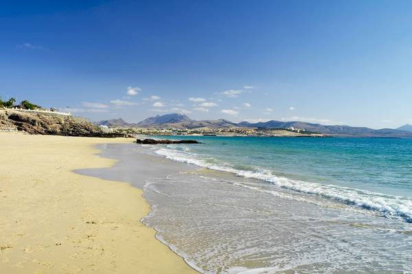 Strand vor dem H10 Tindaya Hotel mit blauem Himmel und sanften Wellen