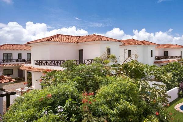 Aussenansicht des Melia Tortuga Beach Hotels mit weissen Villen, roten Dächern und umliegenden Pflanzen.