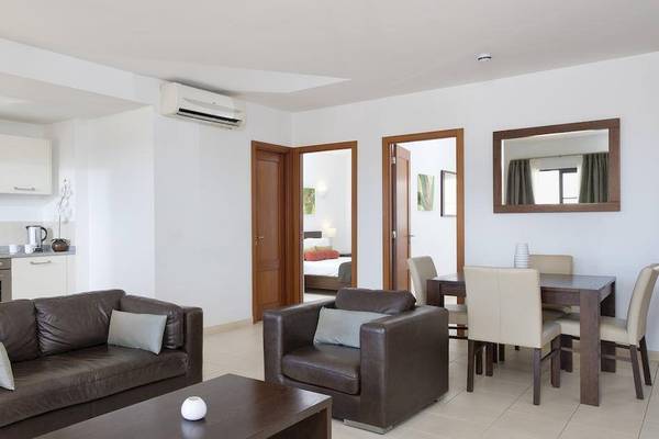 Wohnzimmer im Melia Tortuga Beach Hotel mit braunen Möbeln und weißer Wandgestaltung.