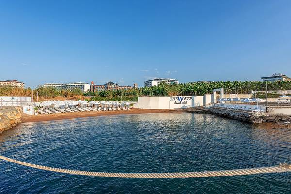Strand des White City Resorts mit umliegenden Gebäuden und Wasser