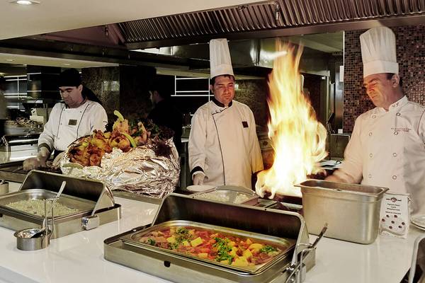 Küchenteam des White City Resorts bereitet Speisen zu, darunter ein Gericht mit Feuer.