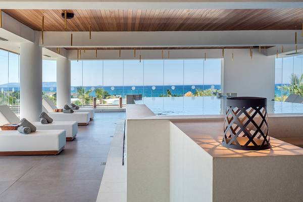 Innenansicht des Stella Island Luxury Resort & Spa mit Loungebereich und Blick auf das Meer.