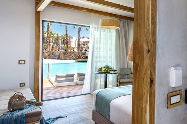 Innenansicht des Stella Island Luxury Resort & Spa Zimmer mit Blick auf den Pool