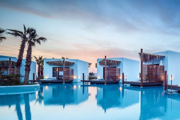 Stella Island Luxusresort & Spa mit Blick auf den Pool und die Cabanas am Abend