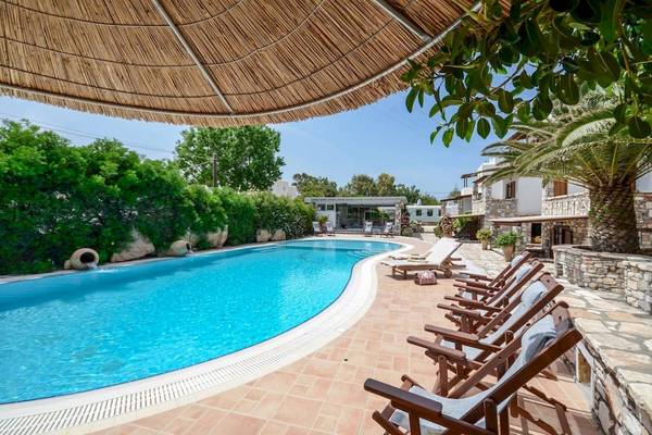 Außenpoolbereich der Villa Romantica mit Sonnenliegen und einem Sonnenschirm.