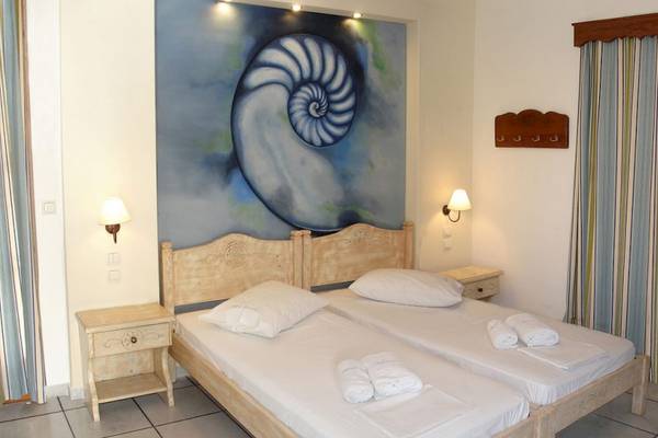 Zwei Betten im Schlafzimmer der Villa Romantica mit einer großen Schnecke am Wand