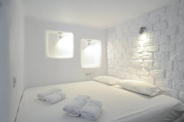 Schlafzimmer in der Villa Romantica mit weißen Wänden, einem Bett und zwei Kissen.