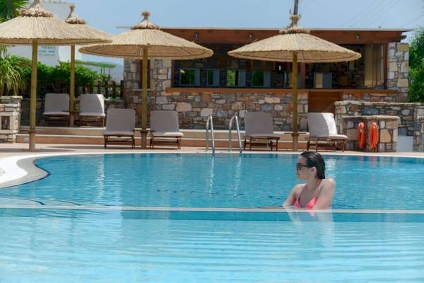 Frau im Pool der Villa Romantica mit Sonnenschirmen und Bar im Hintergrund.
