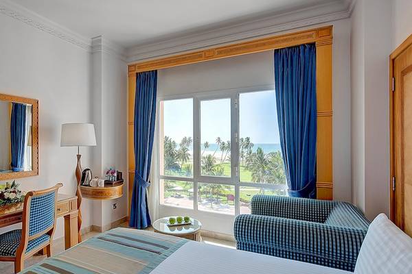 Innenansicht eines Hotelzimmers im Crowne Plaza Resort Salalah mit Blick auf das Meer.