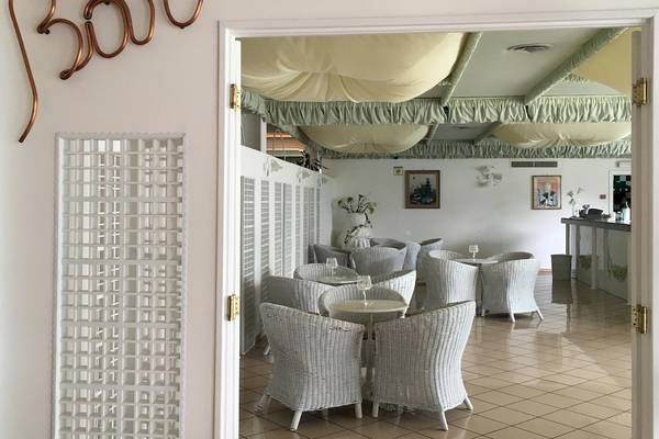 Innenansicht des Loungebereichs im Sierra Silvana Hotel mit weißen Möbeln und einem offenen Eingang.