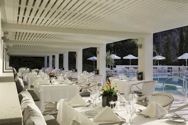 Poolseite Restaurant des Alkyna Lifestyle Beach Resorts mit weißen Tischen, Stühlen und Sonnenschirmen.