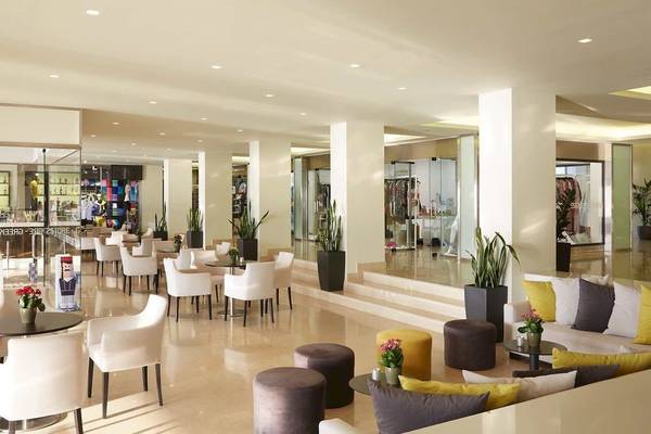 Lobby des Alkyna Lifestyle Beach Resorts mit weißen Stühlen, Tischen und Pflanzen