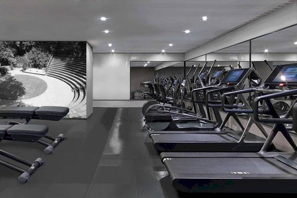 Fitnessraum im Alkyna Lifestyle Beach Resort mit modernen Laufbändern und einer großen Wandprojektion.