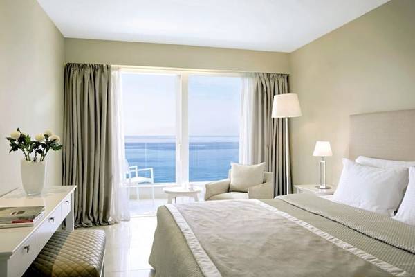 Zimmer mit Meerblick im Alkyna Lifestyle Beach Resort, mit Bett, Tisch, Blumenvase und Meersicht.