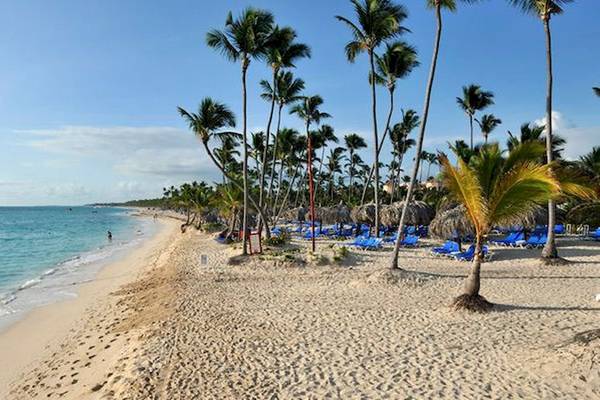 Strand des Bahia Principe Grand Bavaro Hotels mit blauem Himmel und weißen Palmen