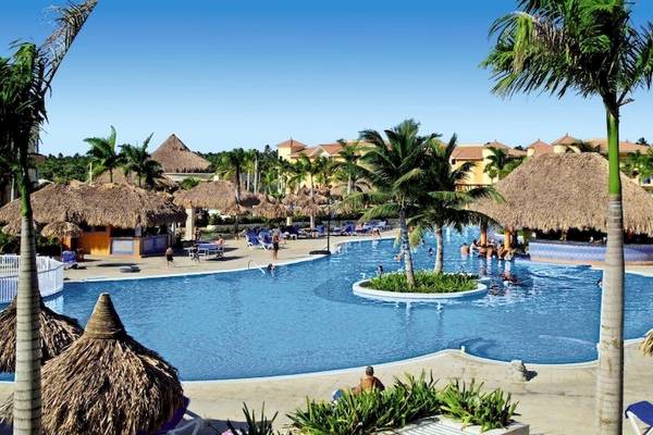 Außenpool des Bahia Principe Grand Bavaro Hotels mit vielen Gästen und Palmen.