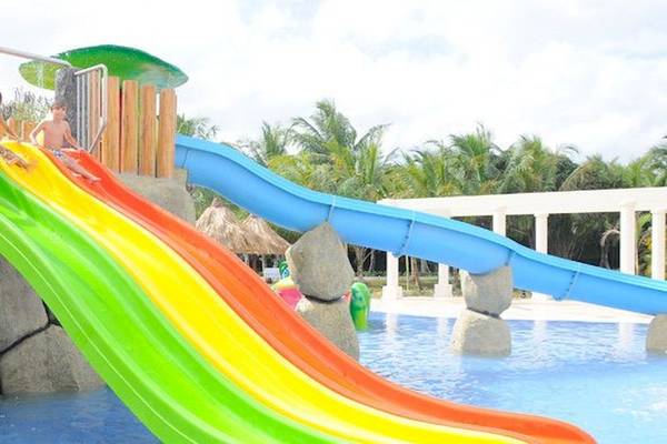 Kinder spielen auf einer Regenbogenrutsche im Wasserpark des Bahia Principe Grand Bavaro.