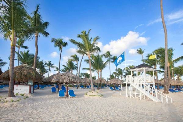 Strand des Bahia Principe Grand Bavaro mit Sonnenliegen und Palmen