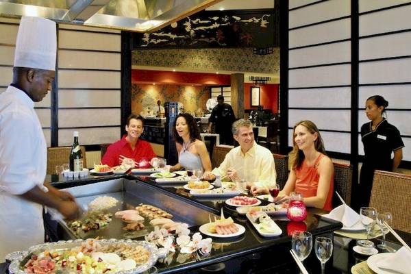 Sushi-Buffet im Bahia Principe Grand Bavaro Hotel mit Gästen und einem Koch.