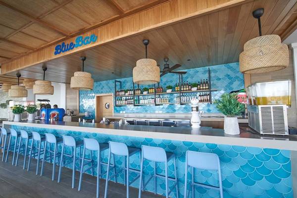 Innenansicht der Blue Bar im Bahia Principe Grand Bavaro Hotel mit blauen Sitzbänken und Bartheken.