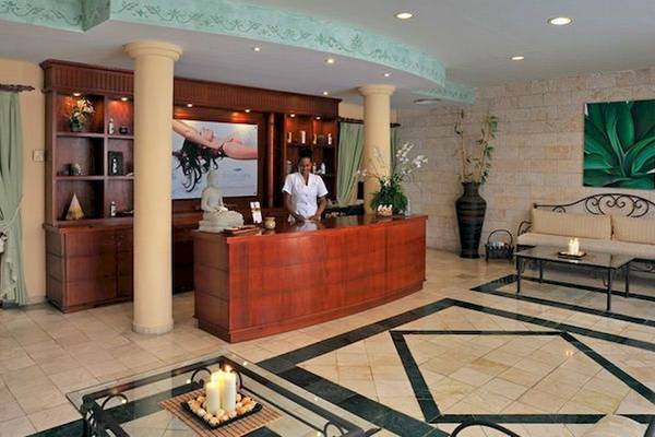 Empfangsbereich des Bahia Principe Grand Bavaro Hotels mit Rezeption, Sofas und Dekoration.