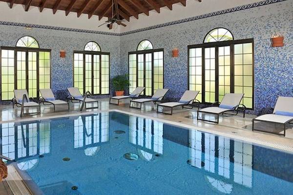 Schwimmbad im Bahia Principe Grand Bavaro Hotel mit blauen Wänden und Lounge-Stühlen