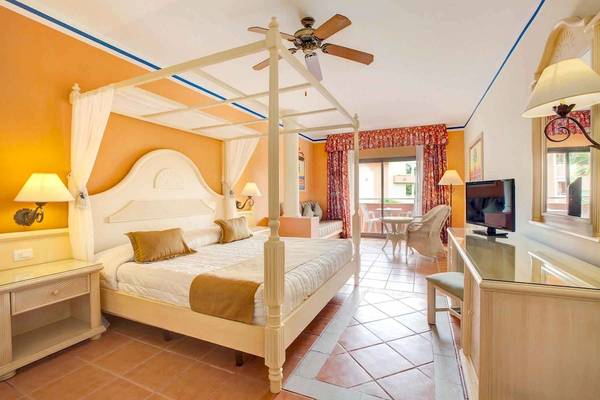 Hotelzimmer mit Baldachin-Bett, Fernseher, Schreibtisch und Balkon im Bahia Principe Grand Bavaro