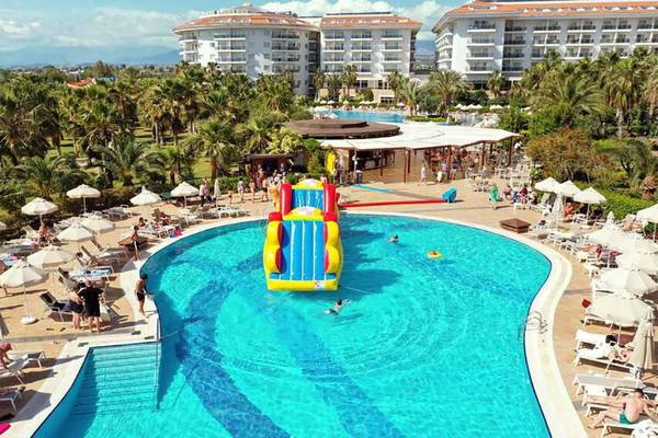 Außenbereich des Seaden Sea World Resort & Spa mit Pool, Wasserrutsche und Sonnenliegen.