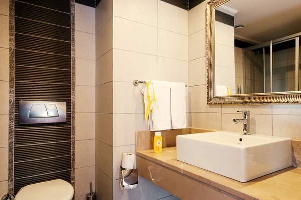 Badezimmer im Seaden Sea World Resort & Spa mit einer Toilette, einem Waschbecken und einem Spiegel.