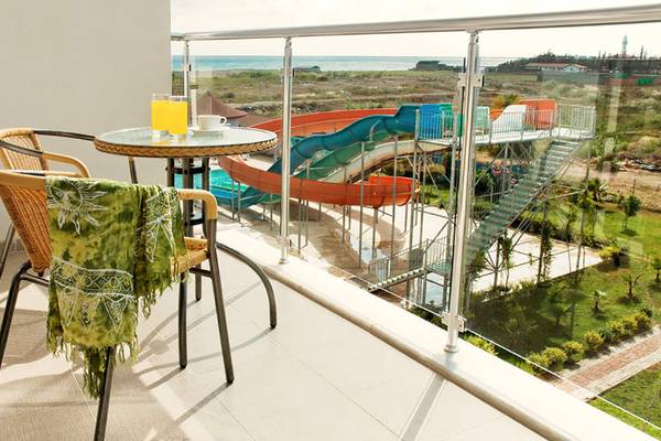 Balkon mit Tisch und Getränken, Blick auf Wasserrutsche im Seaden Sea World Resort & Spa.