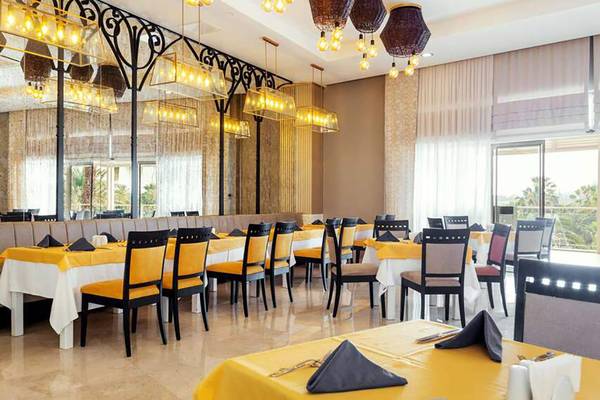 Restaurant im Seaden Sea World Resort & Spa mit gelben und weißen Tischdecken und modernen Möbeln.