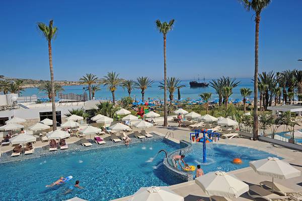Außenpool des Nelia Beach Hotel & Spa mit Palmen und Meerblick