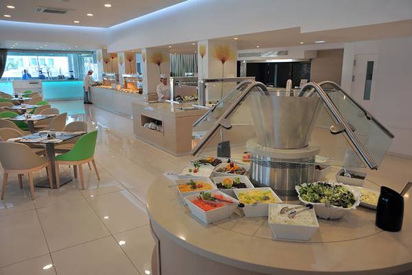 Buffet-Bereich des Nelia Beach Hotel & Spa mit verschiedenen Speisen und Angestellten.