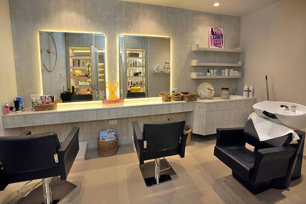 Friseursalon im Nelia Beach Hotel & Spa mit Spiegeln, Stühlen und Waschbecken.