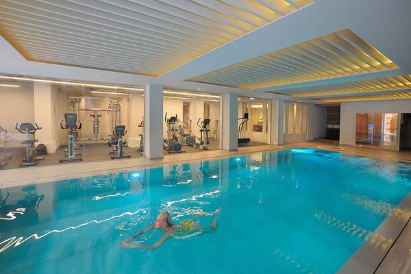 Eine Frau schwimmt in einem großen Pool im Fitnessstudio des Nelia Beach Hotel & Spa.