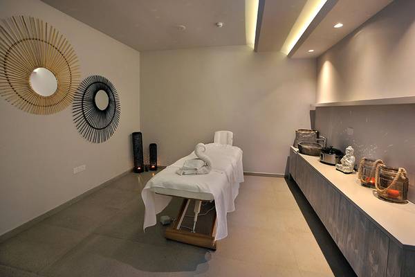 Behandlungsraum im Nelia Beach Hotel & Spa mit Massagetisch, Kerzen und Dekor