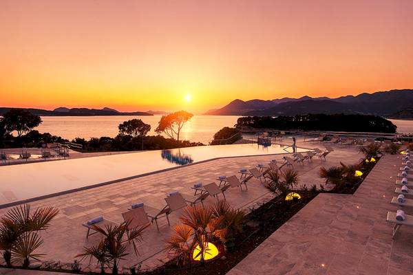 Sonnenuntergang am Pool des Valamar Argosy Hotels mit Blick auf das Meer und die Berge.