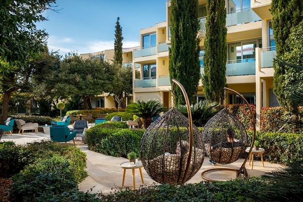 Lounge-Bereich des Valamar Argosy Hotels mit hängenden Sessel und Gartenmöbeln.