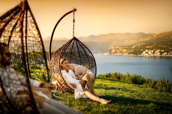 Zwei Frauen in Himmelbetten am Strand mit Meerblick im Valamar Argosy Hotel.