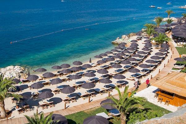 Luftaufnahme des Valamar Argosy Hotels mit Strand, Sonnenliegen und Palmen.