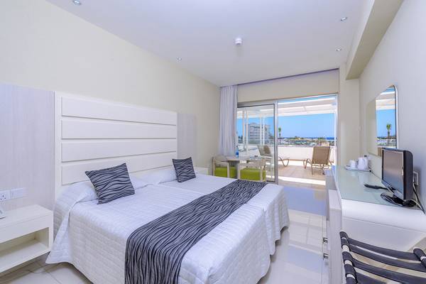 Tasia Maris Sands Hotelzimmer mit Doppelbett, Fernseher und Terrassenzugang.