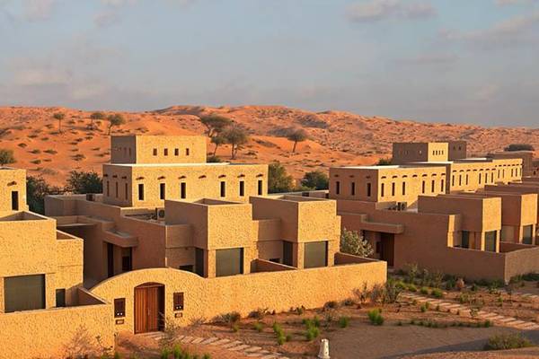 Das Ritz-Carlton Ras Al Khaimah in der Al Wadi Wüste, zeigt eine Reihe von Gebäuden in der Wüstenlandschaft.