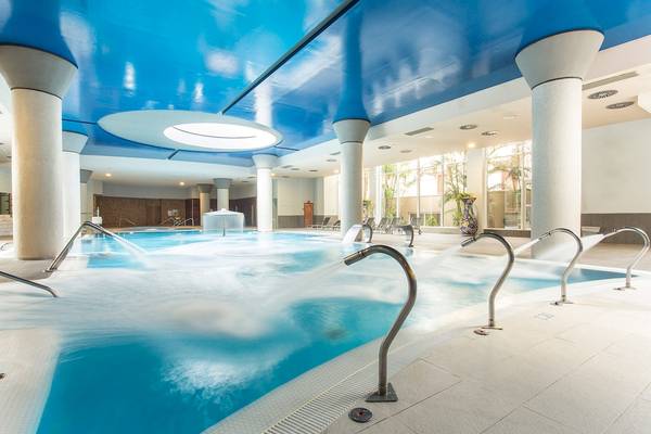 Innenpool des Landmar Costa Los Gigantes Hotels mit blauer Decke und Wasserstrahlen.