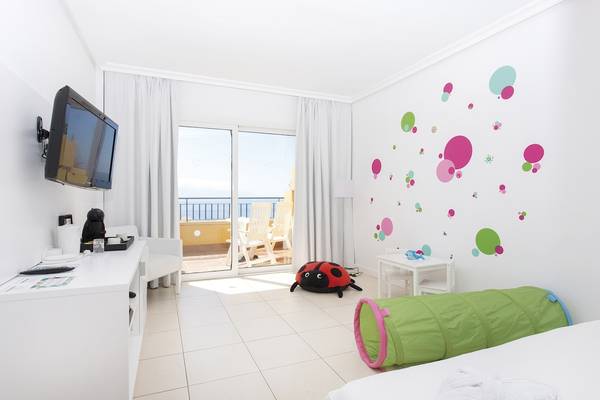Innenansicht eines Zimmers im Landmar Costa Los Gigantes Hotel mit Fernseher, Schreibtisch und Balkon.