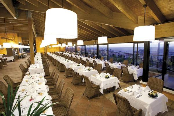 Innenansicht des Restaurants im Landmar Costa Los Gigantes Hotel mit vielen gedeckten Tischen und Blick auf die Küste.
